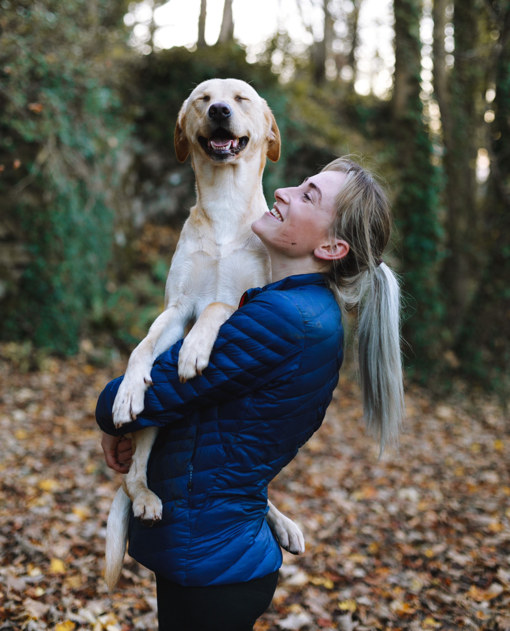 Happy lady and her dog in forest. 